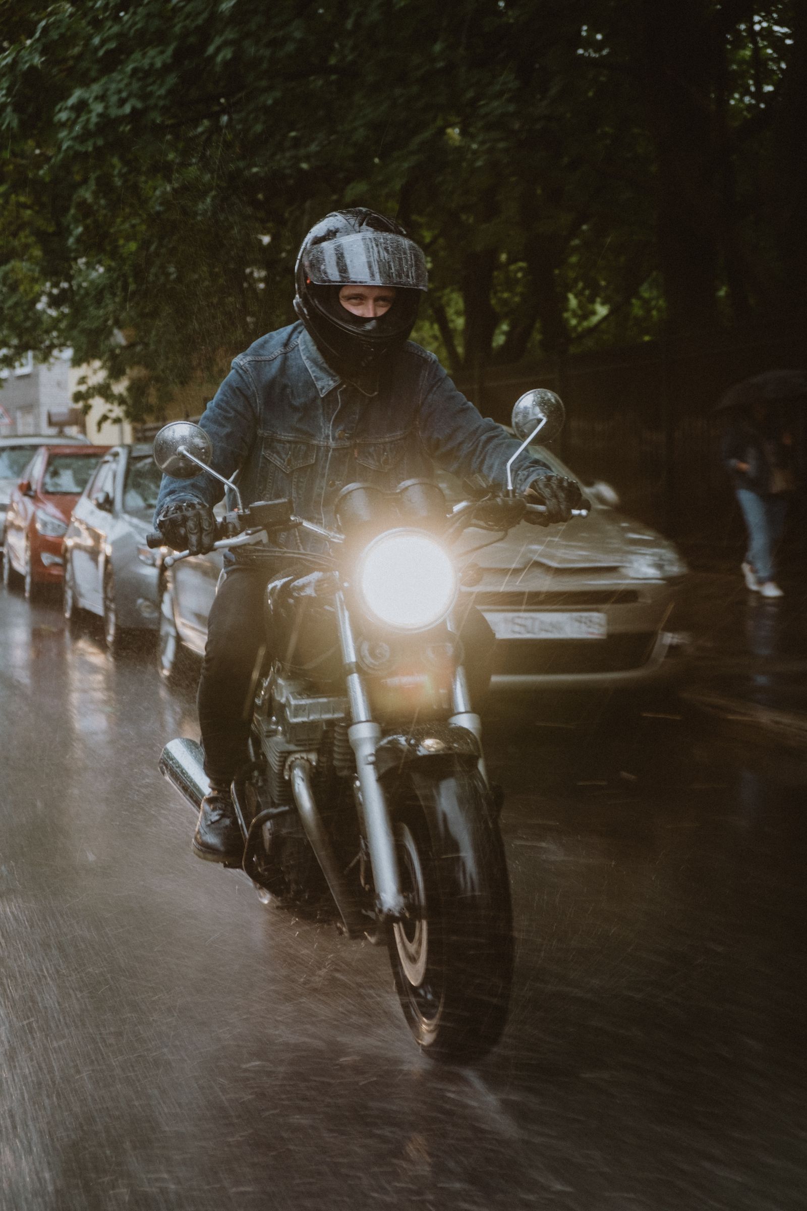 Capa de chuva vestida por um motociclista sob chuva urbana