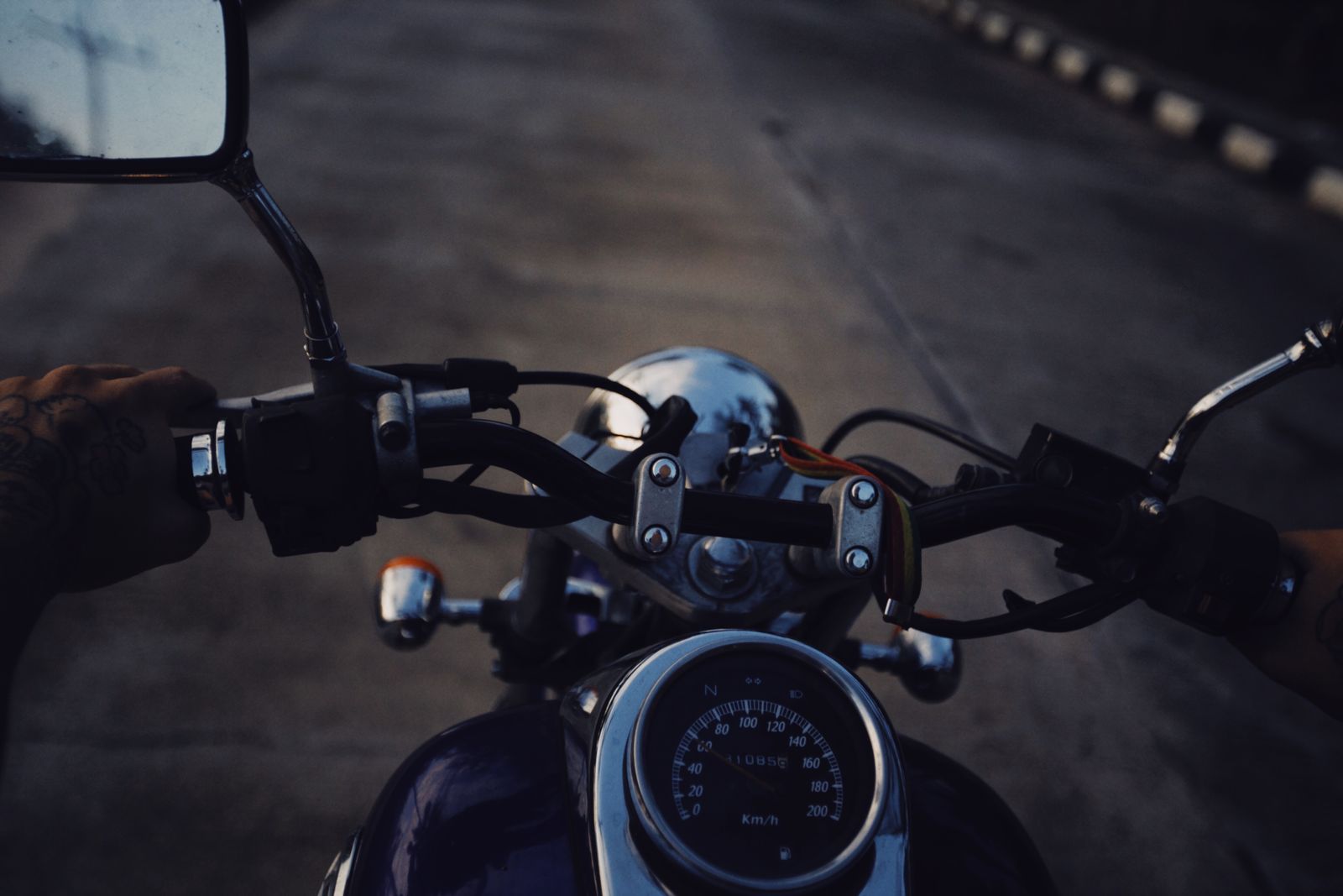 Detalhe das mãos no guidão de uma moto